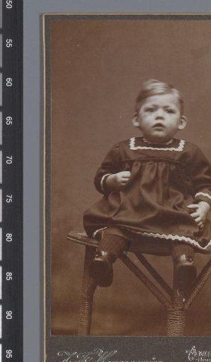 Portrait of an unknown child, seated on a table