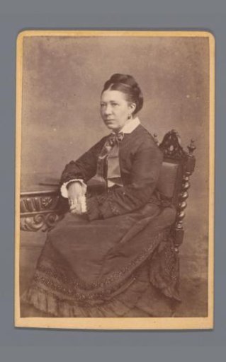 Portrait of an unknown woman, seated at a table