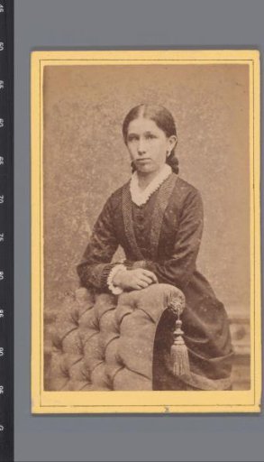 Portrait of an unknown woman, standing behind an armchair