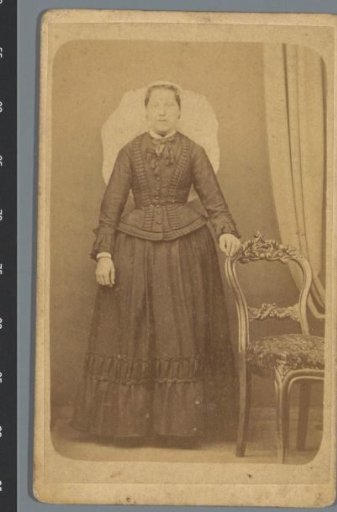 Portrait of an unknown woman next to a chair