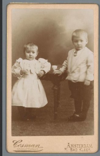 Portrait of two unknown children at a table with tableware