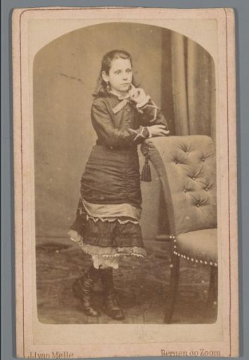Portrait of an unknown girl behind a chair