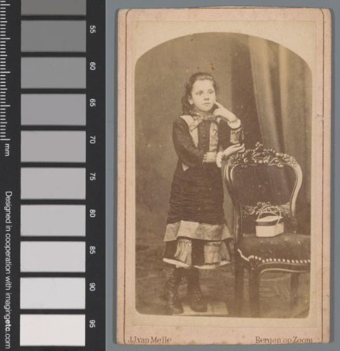 Portrait of an unknown girl behind a chair
