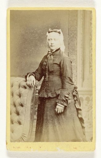 Portrait of an unknown woman behind an armchair
