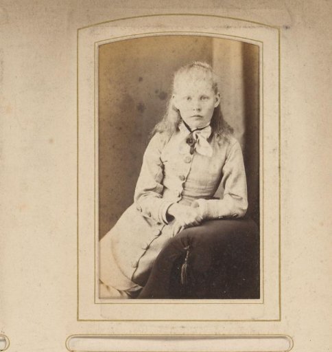 Portrait of a girl leaning on the arm of an armchair