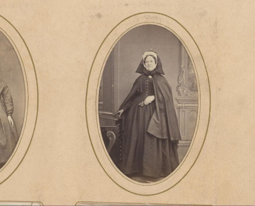 Portrait of a standing woman in a cape with a cap and hood