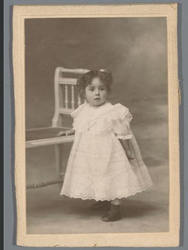 Portrait of an unknown child by a chair