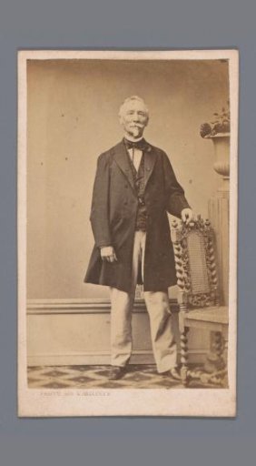 Portrait of an unknown man standing by a chair