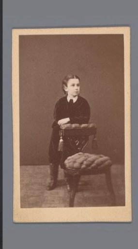 Portrait of an unknown boy, leaning over a chair