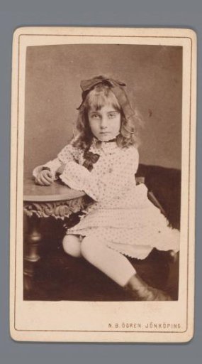 Portrait of an unknown girl, identified as Lily, seated at a table