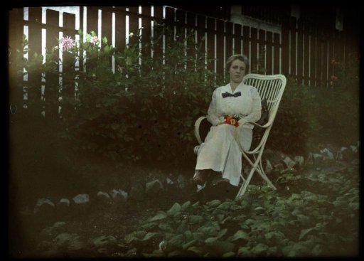 Woman sitting in a garden near Dahlias