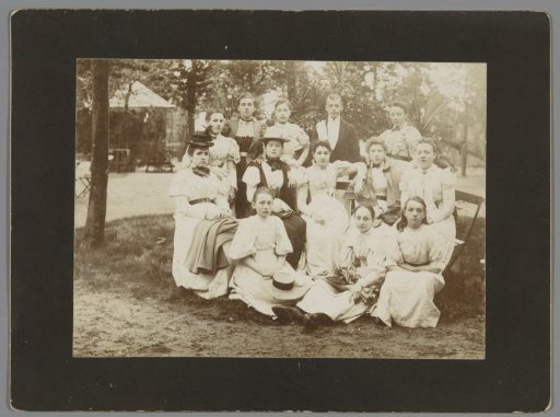 Group portrait of twelve unknown young women and a young man in a park