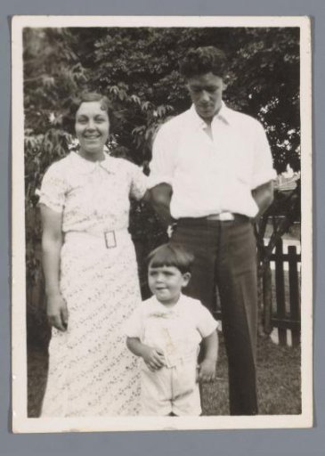 Family portrait of a man, woman and boy, Fred, Nell and Barry, in a garden
