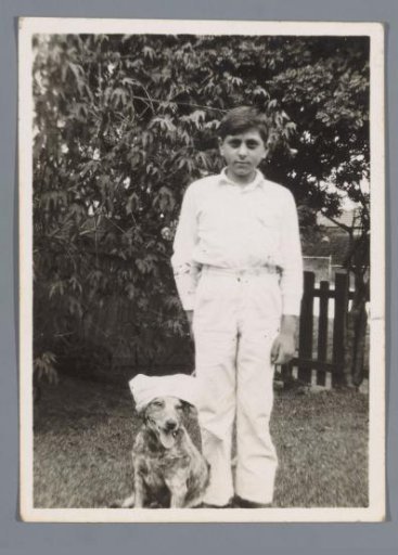 Portrait of an unknown boy with a dog in a garden