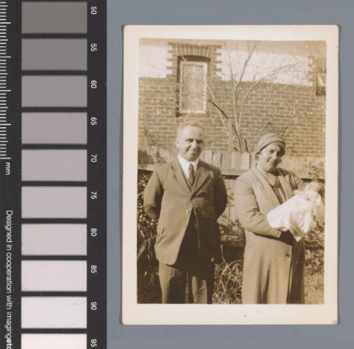 Portrait of an unknown man and woman with a baby in a garden