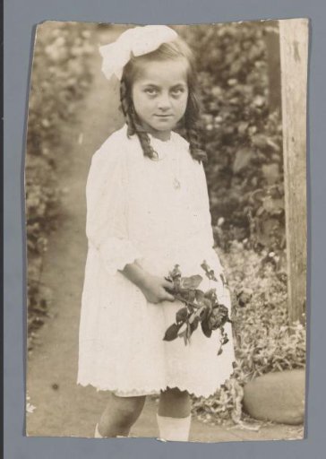 Portrait of an unknown girl in a garden with flowers in her hand