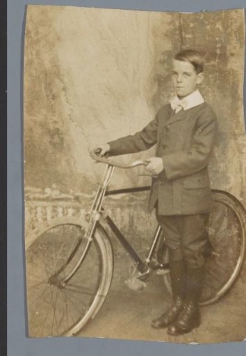 Portrait of an unknown boy with a bicycle