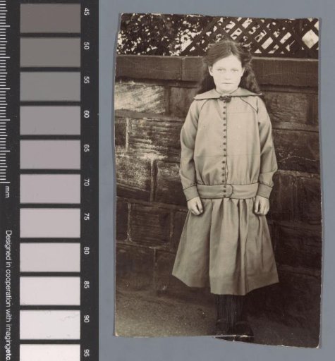 Portrait of an unknown girl before an exterior wall