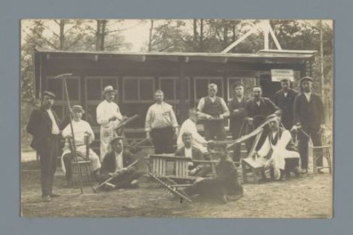 Group portrait of unknown men with tools (presumably) for a workshop in a forest
