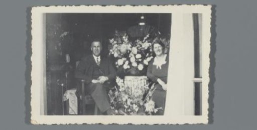 Man and woman among flowers in a doorway