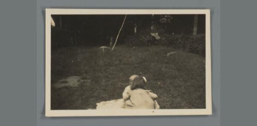 Two small children on a grassy field