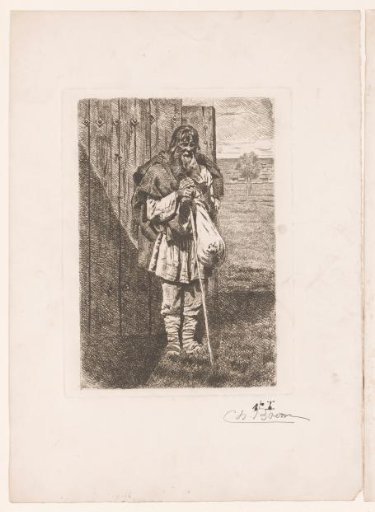 Old man with a bundle in front of a fence
