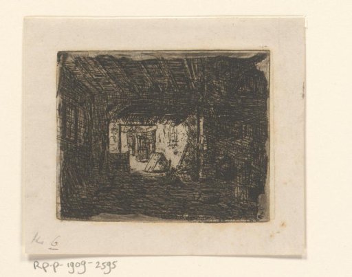 View through a dark barn onto a light courtyard