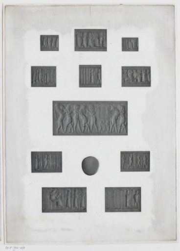 Eleven rectangular carved stones and one round stone