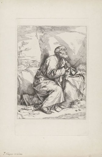 Old man in prayer by a rock
