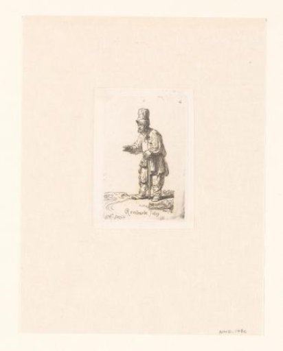 A peasant in a high cap, standing leaning on a stick