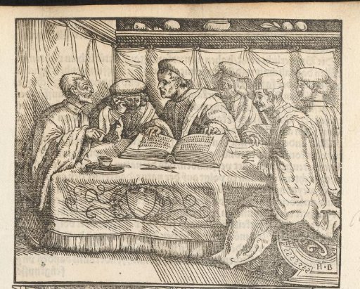 Men reading a book at a table