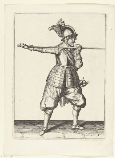 Soldier carrying his spear horizontally at shoulder height with both hands, his right hand at the butt of the weapon