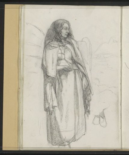 Standing woman with a cape in a mountain landscape
