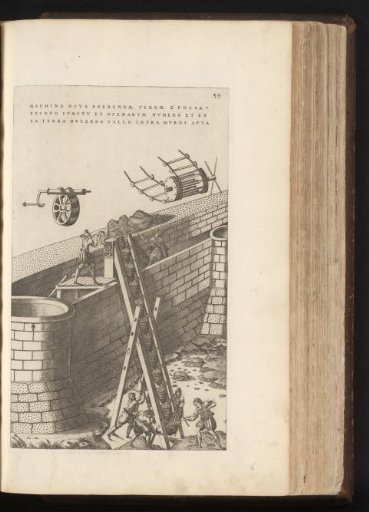 Men hoisting sand onto a wall using a machine