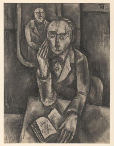 Man seated at a table with an open book