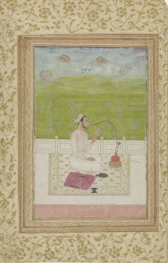 Young man smoking a hookah, seated on a terrace