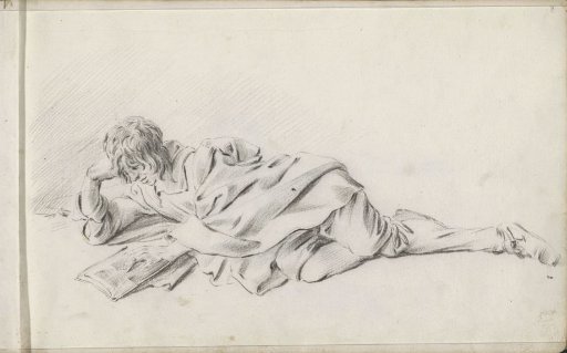 Reclining boy reading a book