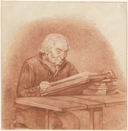 Seated man reading at a table