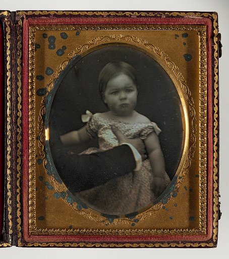The Reluctant Model (Young Child Being Held)