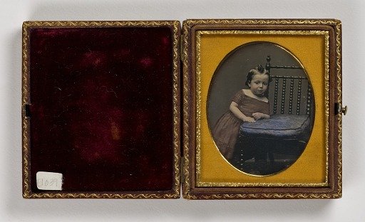 Untitled (Young Girl in Red Dress Leaning on Chair Seat)